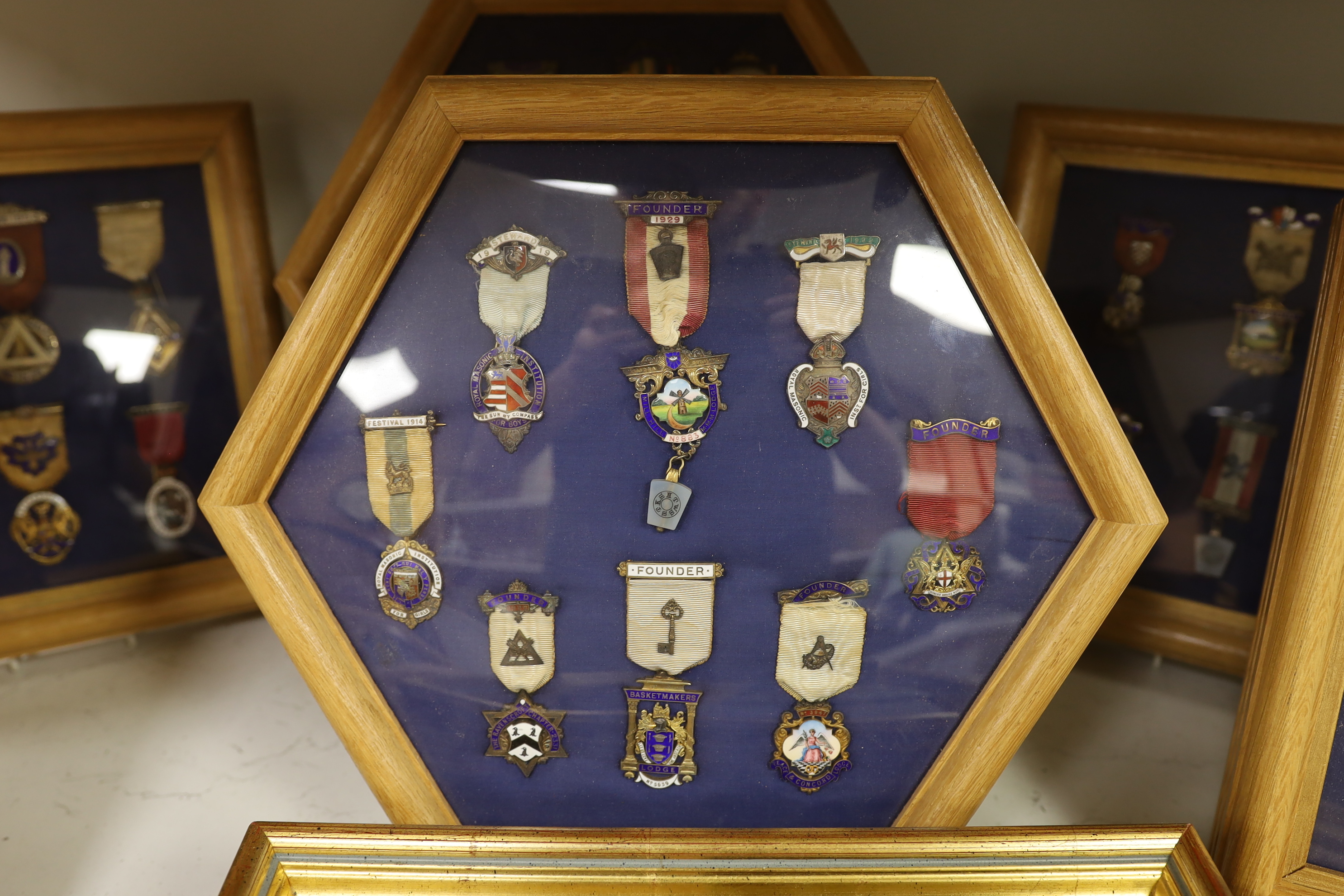 A collection of 20th century enamelled silver gilt or gilt metal Masonic medals with ribbons and clasps, approx. 47 in silver, and similar badges (mounted in 10 cases)